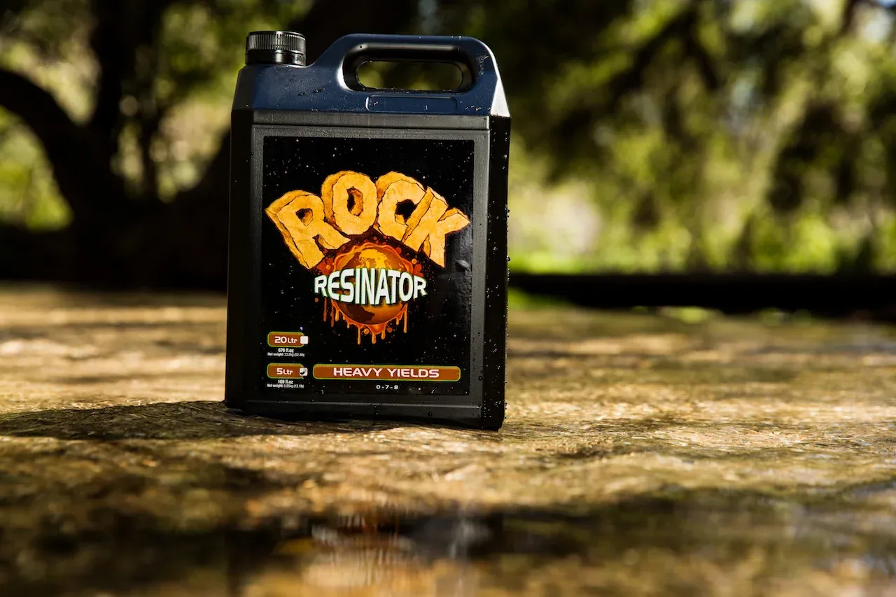 Rock Resinator Kanister Außenaufnahme Rock Resinator Kanister mit Heavy-Yields-Etikett auf nassem Stein vor grünem Hintergrund